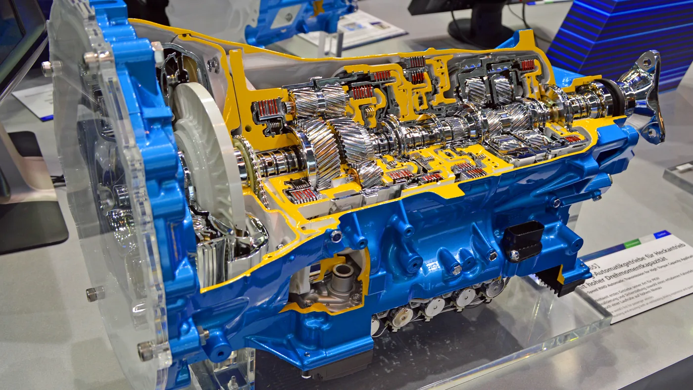 Cutaway of a blue and yellow 10-speed automatic transmission on display, showing its gear sets and clutch packs