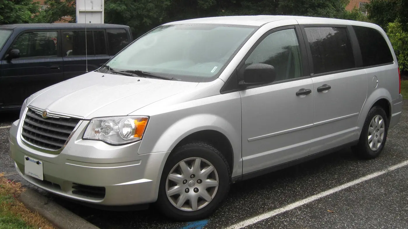 Silver 2008 Chrysler Town and Country minivan parked in a lot, seen from the front left