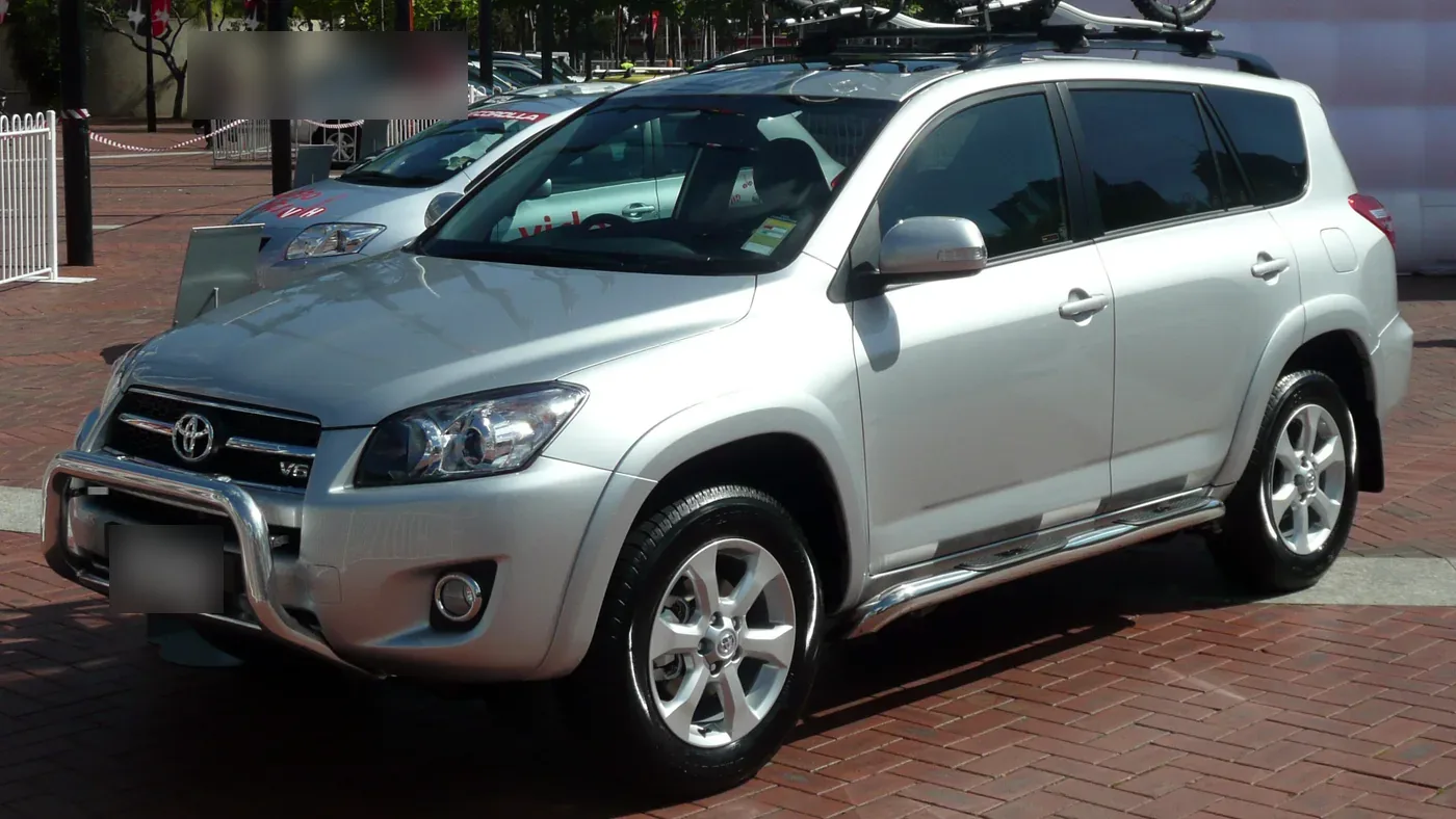 Silver 2008 Toyota RAV4 V6 SUV parked on a brick plaza, seen from the front left with a roof rack